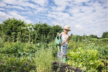 Little boy watering seedling in a community garden, Bavaria, Germany Foto de stock - Sin royalties Premium, Código: 6121-08859036