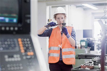 Young female engineer repairing machine part in an industrial plant, Freiburg im Breisgau, Baden-Württemberg, Germany Stock Photo - Premium Royalty-Free, Code: 6121-08859281