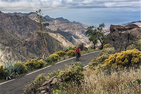 simsearch:649-08085932,k - Woman riding electric bicycle on mountain road Photographie de stock - Premium Libres de Droits, Code: 6121-08972683