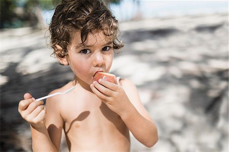 Portrait of little boy eating passion fruit Foto de stock - Sin royalties Premium, Código: 6121-09062358