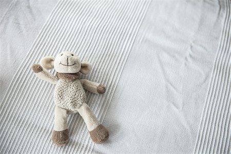 stuffed animal - Teddy bear lying on bed Stock Photo - Premium Royalty-Free, Code: 6121-09062417