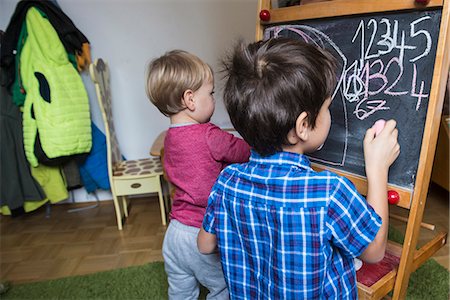 Brothers writing on a blackboard, Munich, Germany Stock Photo - Premium Royalty-Free, Code: 6121-09147045