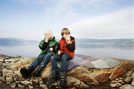 simsearch:6122-07703483,k - 2 boys eating fruit at lake Fotografie stock - Premium Royalty-Free, Codice: 6122-07691945