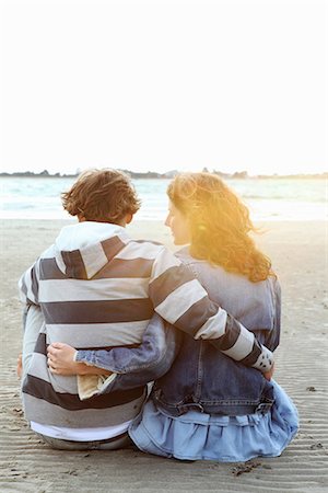 flare couple sunset - A couple watching the sunset at a beach Stock Photo - Premium Royalty-Free, Code: 6122-07691931