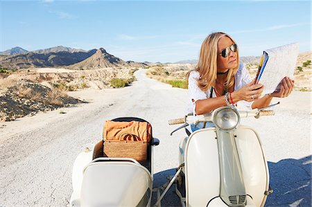 Woman Sitting on motorbike with map Stock Photo - Premium Royalty-Free, Code: 6122-07692066