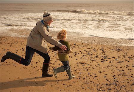 family wind energy - Woman running playing with boy on beach Stock Photo - Premium Royalty-Free, Code: 6122-07692371