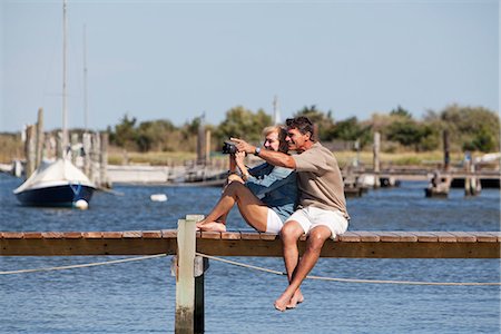 Couple sitting on a dock Foto de stock - Sin royalties Premium, Código: 6122-07692552