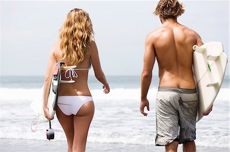 Girl walking with surfboard in water Stock Photo - Premium Royalty-Free, Code: 6122-07693297