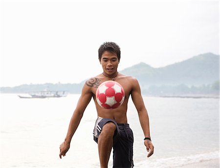 simsearch:6113-07159157,k - Guy playing football on beach Stock Photo - Premium Royalty-Free, Code: 6122-07693318