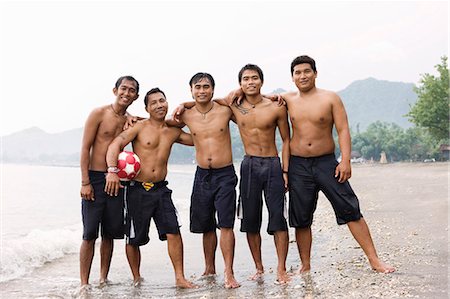 Guys posing for camera on beach Stock Photo - Premium Royalty-Free, Code: 6122-07693322