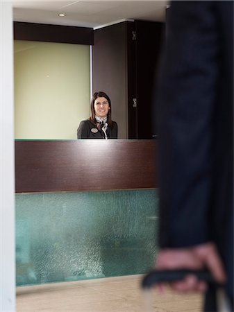 simsearch:6122-07693573,k - Man aproaching front desk of a hotel Stock Photo - Premium Royalty-Free, Code: 6122-07693573