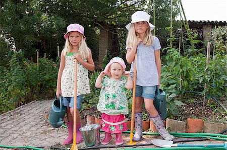 rain boots for girls - Girls gardening in vegetable garden Stock Photo - Premium Royalty-Free, Code: 6122-07694774