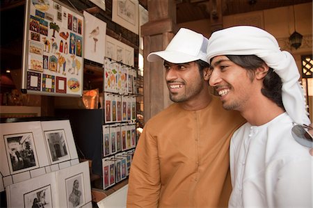 dubai men headdress - Middle Eastern men looking at pictures Stock Photo - Premium Royalty-Free, Code: 6122-07694907