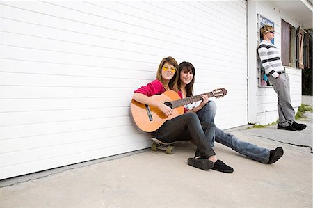 Two girls sitting on floor with guitar Stock Photo - Premium Royalty-Free, Code: 6122-07695155