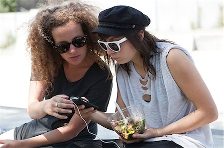 skateboarder (female) - Friends looking at mp3 player Stock Photo - Premium Royalty-Free, Code: 6122-07695188