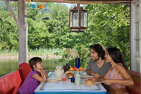 simsearch:6122-07695474,k - Family having breakfast together outdoors Stock Photo - Premium Royalty-Free, Code: 6122-07695453