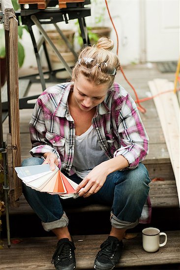 Woman looking at color swatch Stock Photo - Premium Royalty-Free, Image code: 6122-07695847