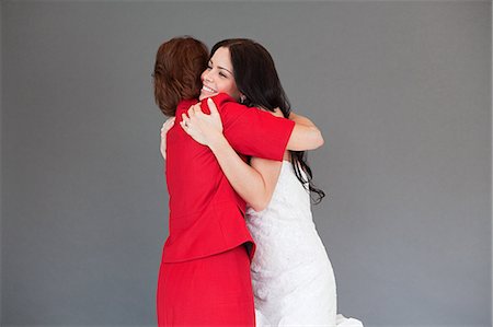 fashion mothers hug - Daughter trying on wedding dress, embracing mother Stock Photo - Premium Royalty-Free, Code: 6122-07695836