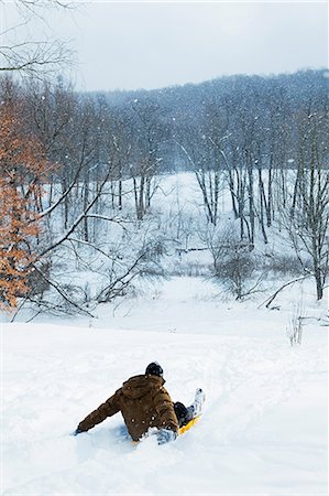 simsearch:400-06638465,k - Mid adult man sledging down hill Stock Photo - Premium Royalty-Free, Code: 6122-07696517