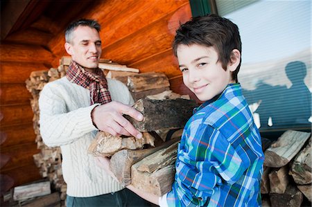 family in log cabin - Father and son holding logs Stock Photo - Premium Royalty-Free, Code: 6122-07696653