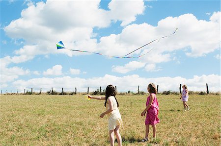 flying kites - Three girls flying kite in field Stock Photo - Premium Royalty-Free, Code: 6122-07696742