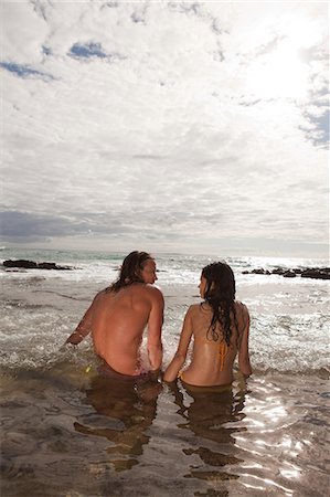 puerto rico beach - Couple sitting in sea, rear view Stock Photo - Premium Royalty-Free, Code: 6122-07696963