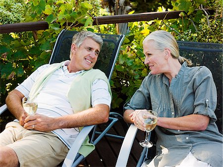 simsearch:6122-07697376,k - Couple sitting on garden chairs with wine Stockbilder - Premium RF Lizenzfrei, Bildnummer: 6122-07697377