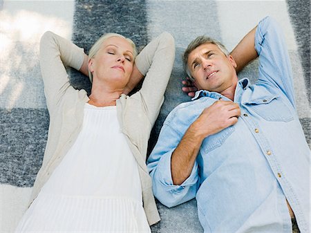 simsearch:649-07710419,k - Couple lying on picnic blanket in garden Photographie de stock - Premium Libres de Droits, Code: 6122-07697382