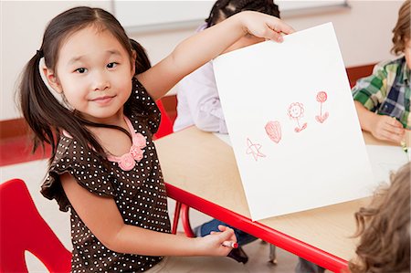 daycare - Girl with a crayon drawing Stock Photo - Premium Royalty-Free, Code: 6122-07697460