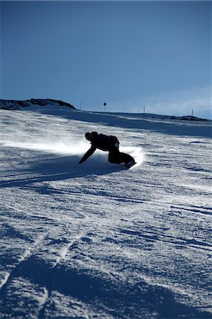 snowboarder powder snow - Male snowboarder sliding down ski slope Stock Photo - Premium Royalty-Free, Code: 6122-07697812