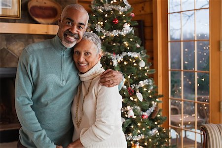 simsearch:614-05662342,k - Mature couple embracing by Christmas tree, portrait Photographie de stock - Premium Libres de Droits, Code: 6122-07697820