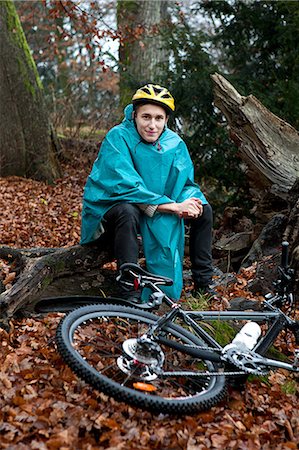 simsearch:614-06002107,k - Young man sitting with bicycle in forest Photographie de stock - Premium Libres de Droits, Code: 6122-07698028