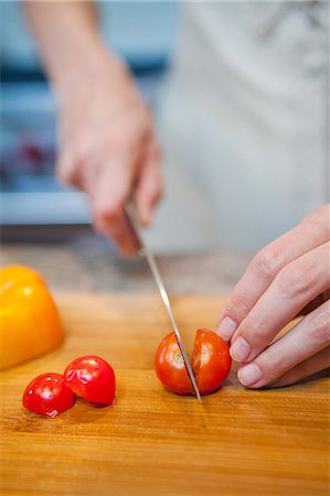 simsearch:695-05769743,k - Mid adult woman slicing cherry tomatoes Stock Photo - Premium Royalty-Free, Code: 6122-07698033
