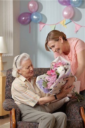 retirement home - Daughter giving senior mother bouquet of flowers Stock Photo - Premium Royalty-Free, Code: 6122-07698194