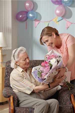 senior home care caucasian - Daughter giving senior mother bouquet of flowers Stock Photo - Premium Royalty-Free, Code: 6122-07698194