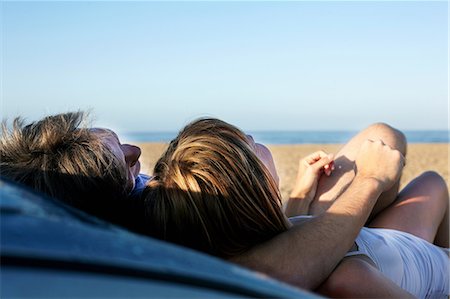 Mid adult couple relaxing on car on beach Stock Photo - Premium Royalty-Free, Code: 6122-07698294