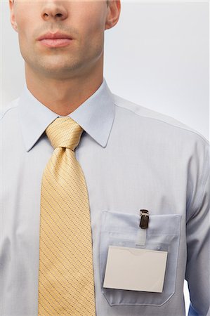 shirt and tie - Young man wearing tie and name badge Stock Photo - Premium Royalty-Free, Code: 6122-07698214