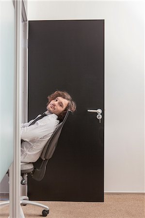 door office - Young man sitting in office doorway Stock Photo - Premium Royalty-Free, Code: 6122-07698231