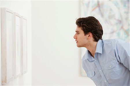 Young man looking at picture in art gallery Stock Photo - Premium Royalty-Free, Code: 6122-07698345