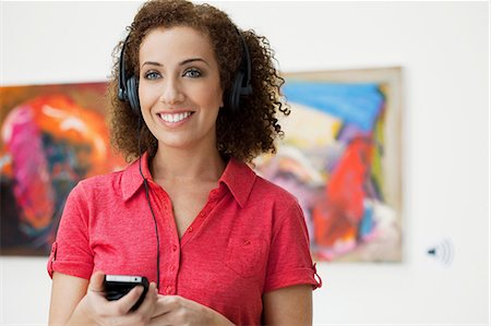 Young woman using audio guide in art gallery Stock Photo - Premium Royalty-Free, Code: 6122-07698329