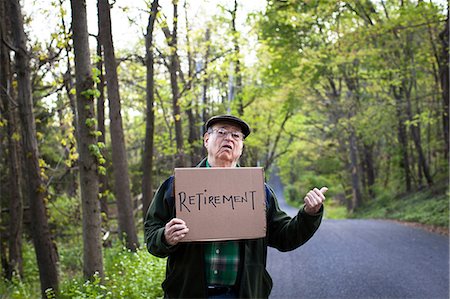 exhausted man on the road - Senior man holding sign in forest, portrait Stock Photo - Premium Royalty-Free, Code: 6122-07698445