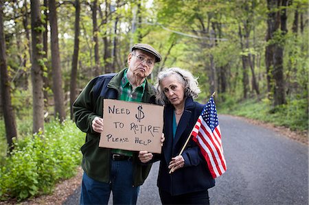 savings - Senior couple holding sign in forest, portrait Stock Photo - Premium Royalty-Free, Code: 6122-07698446
