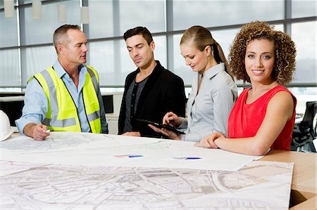 engineer at desk - Engineer with architects looking at blueprints and digital tablet in office Stock Photo - Premium Royalty-Free, Code: 6122-07698407