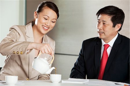 Businesswoman pouring tea for businessman Stock Photo - Premium Royalty-Free, Code: 6122-07698537