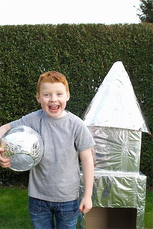 Boy playing with cardboard spaceship Stock Photo - Premium Royalty-Free, Code: 6122-07698896