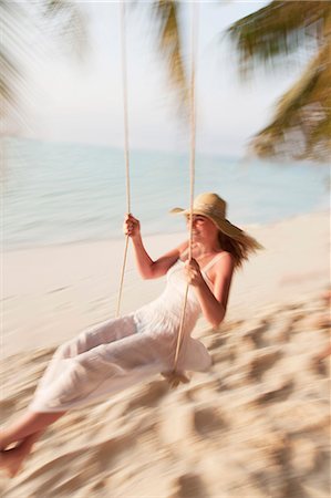 Woman swinging on tropical beach Photographie de stock - Premium Libres de Droits, Code: 6122-07699015