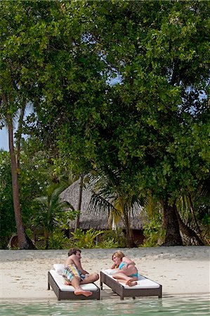 simsearch:6122-07699118,k - Couple relaxing on daybeds at beach Photographie de stock - Premium Libres de Droits, Code: 6122-07699038