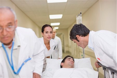 sick men in hospital bed - Doctors rushing patient down hallway Stock Photo - Premium Royalty-Free, Code: 6122-07699197