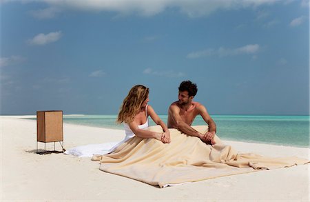 simsearch:6122-07699102,k - Couple sitting in bed on beach Fotografie stock - Premium Royalty-Free, Codice: 6122-07699112
