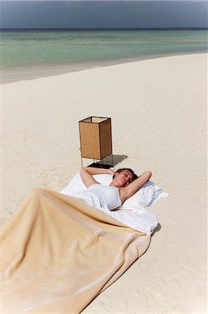 sleep concept - Woman sleeping in bed on beach Stock Photo - Premium Royalty-Free, Code: 6122-07699114